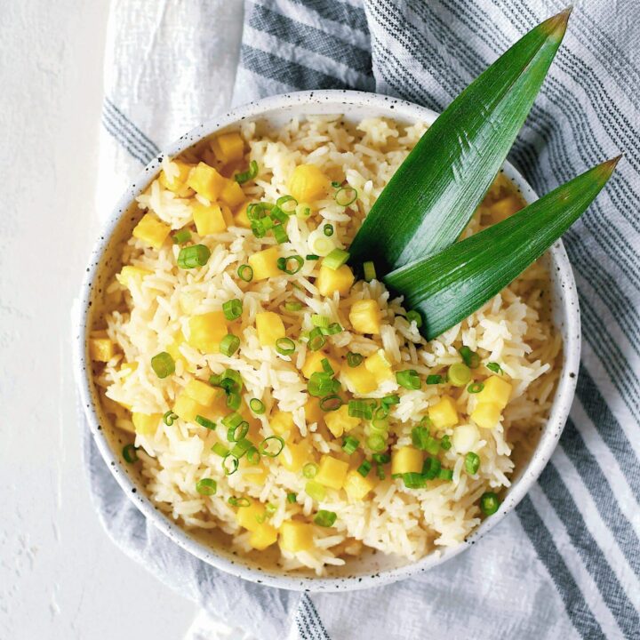 Pineapple Coconut Rice in a bowl topped with diced pineapple and green onions.