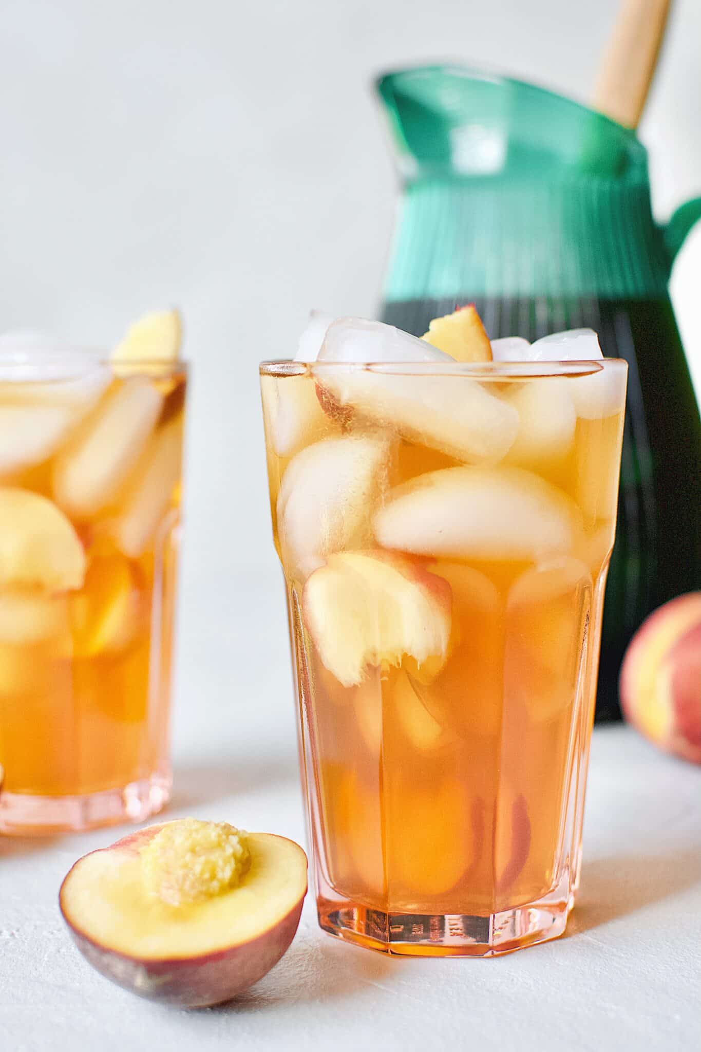 Peach Sangria in an ice filled glass with peach wedges.