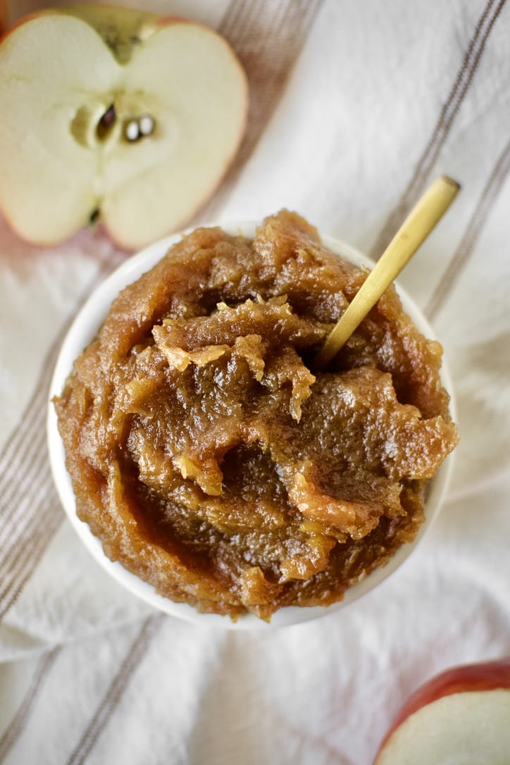 Finished Apple Butter in a dish with a gold spoon in it.