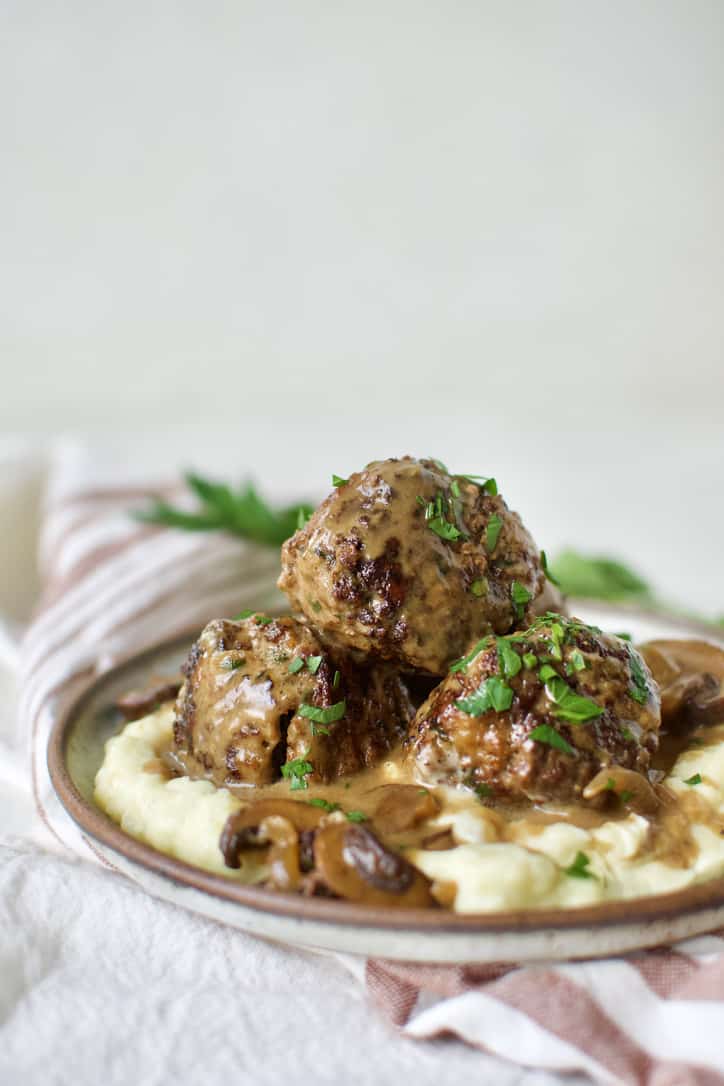 Easy Swedish Meatballs served on a bed of mashed potatoes ready to eat.