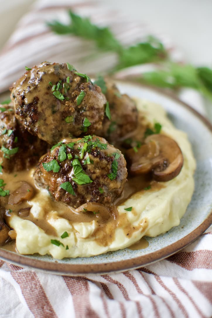 Easy Swedish Meatballs served on a bed of mashed potatoes ready to eat.
