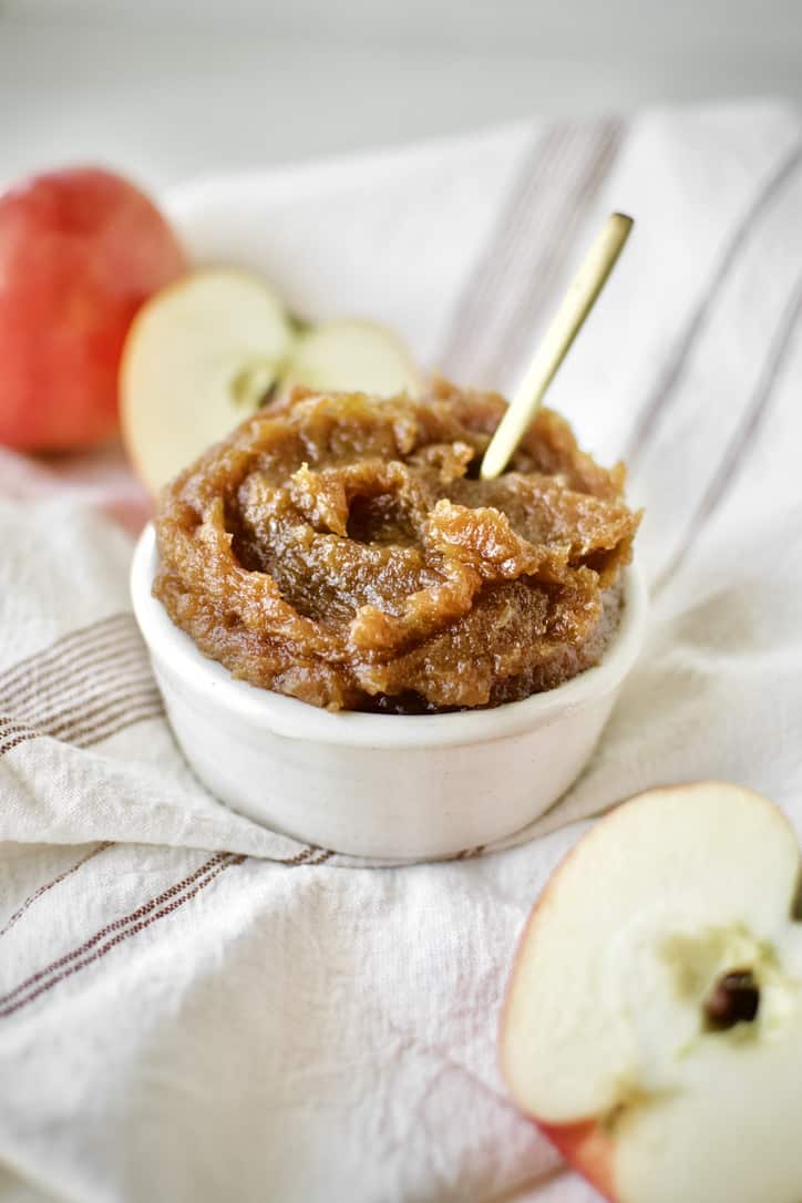 Finished Apple Butter in a dish with a gold spoon in it.