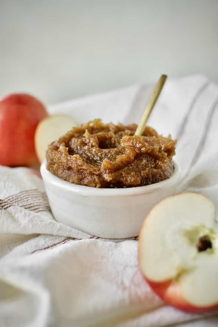 Finished Apple Butter in a dish with a gold spoon in it.