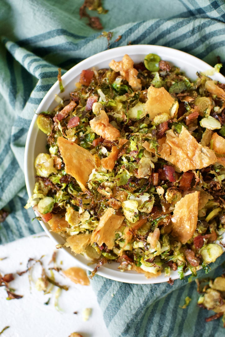 Crispy Brussels Sprouts in a bowl topped with Chicken Cracklings.