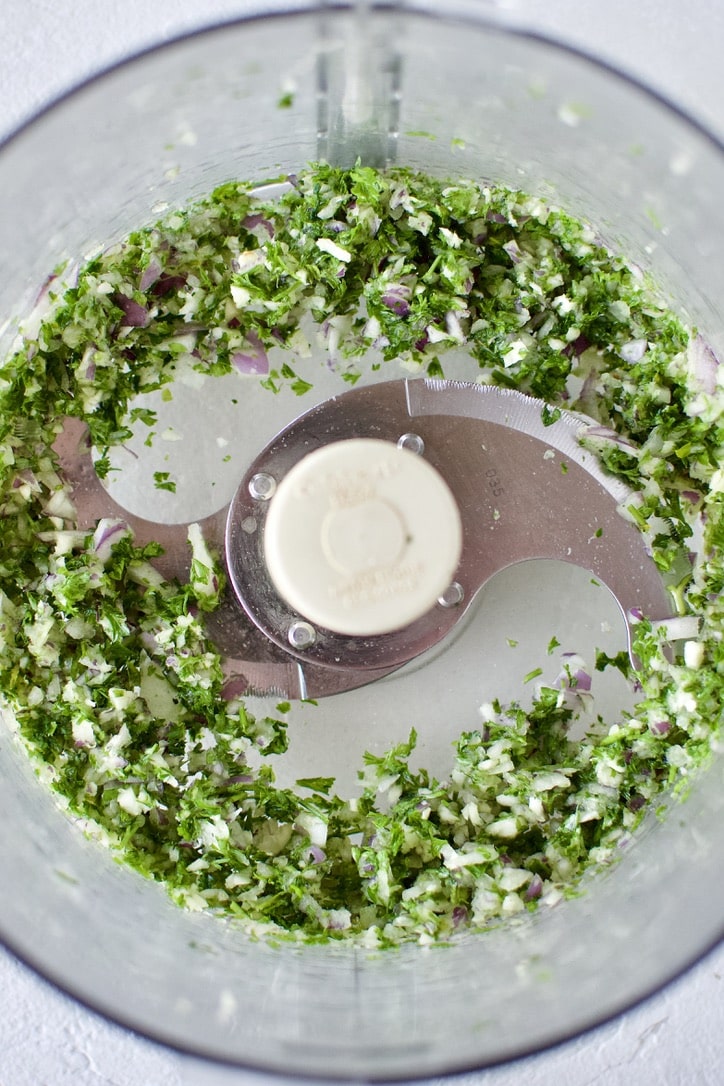 Blended parsley, garlic, and red onion in a food processor.