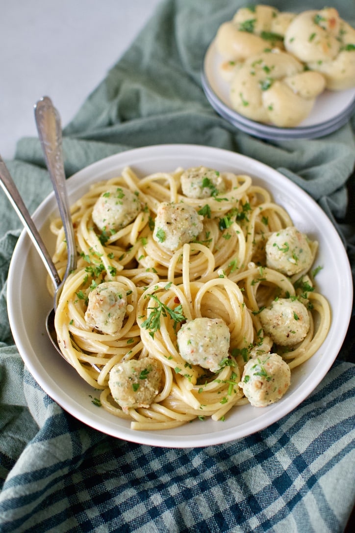 Shrimp Balls served in a white bowl over cooked bucatini pasta.