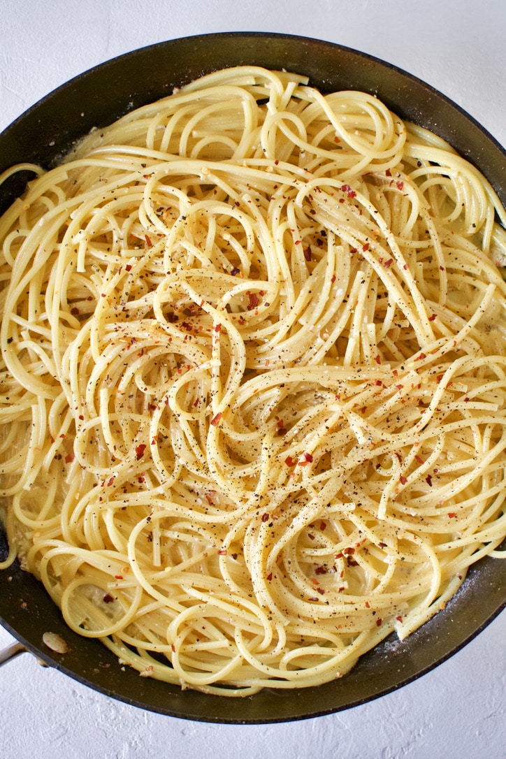 Tossing cooked pasta in the butter and garlic the shrimp balls were cooked in. Seasoned with salt, pepper, and crushed red pepper.