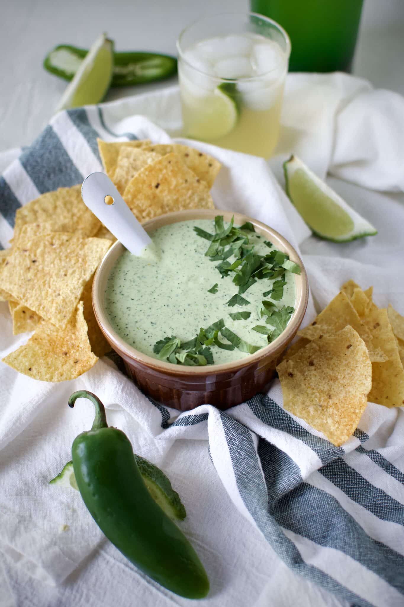 Creamy Jalapeño Dip served with chips and alongside a fresh margarita.