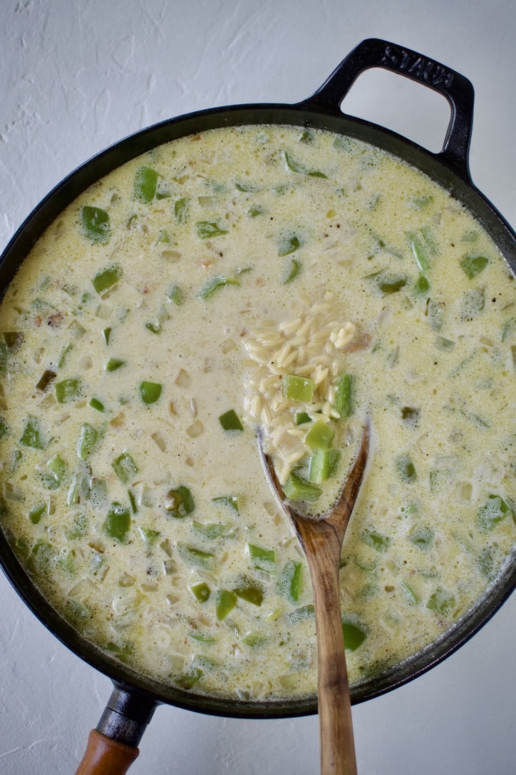 Orzo pasta and vegetables in chicken stock and cream.