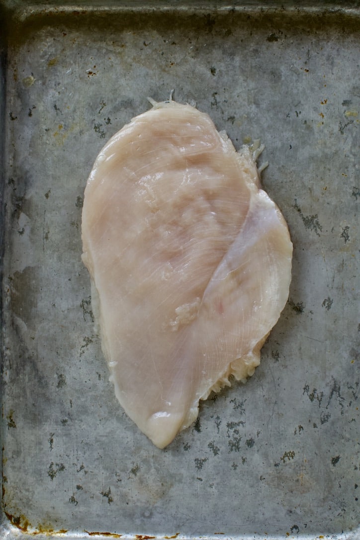 Chicken breast on a sheet pan.