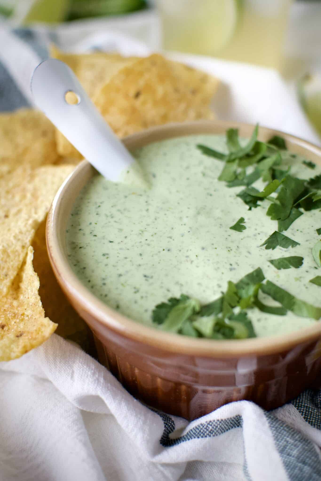 Creamy Jalapeño Dip served with chips and alongside a fresh margarita.