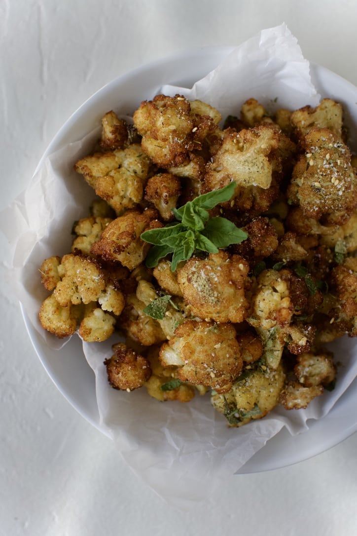 Fried Cauliflower in Olive Oil in a bowl ready to eat. Garnished with Greek seasoning and oregano.