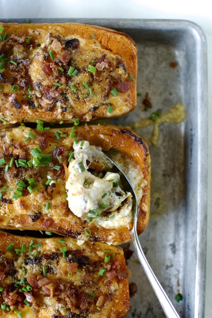 Stuffed Butternut Squash cooked and ready to eat. A spoon in one squash taking a first bite.