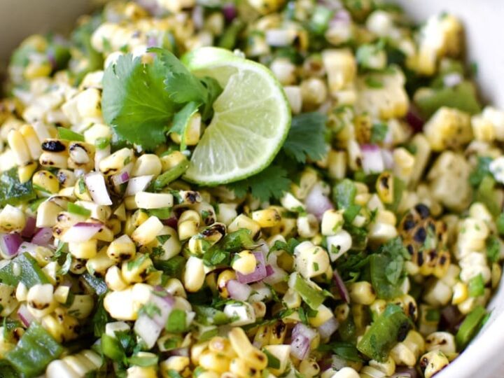 Roasted Chili-Corn Salsa ready to eat garnished with a lime slice and cilantro.