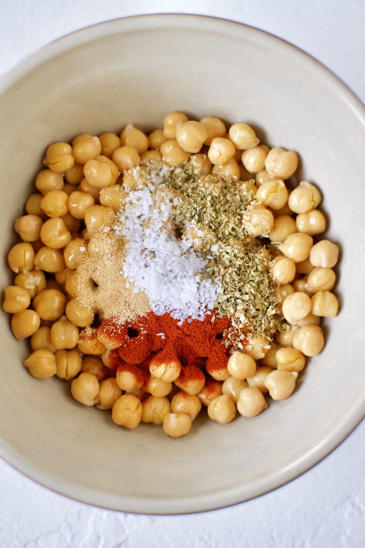 Combining the chickpeas and seasonings in a bowl.