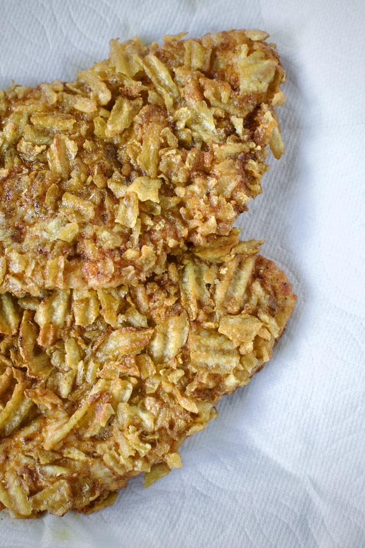 Crispy potato chip chicken breasts draining on paper towels.