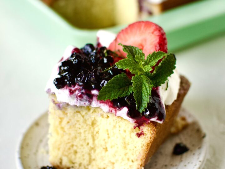 Easy Tres Leches Cake, cut and a slice on a plate ready to eat.