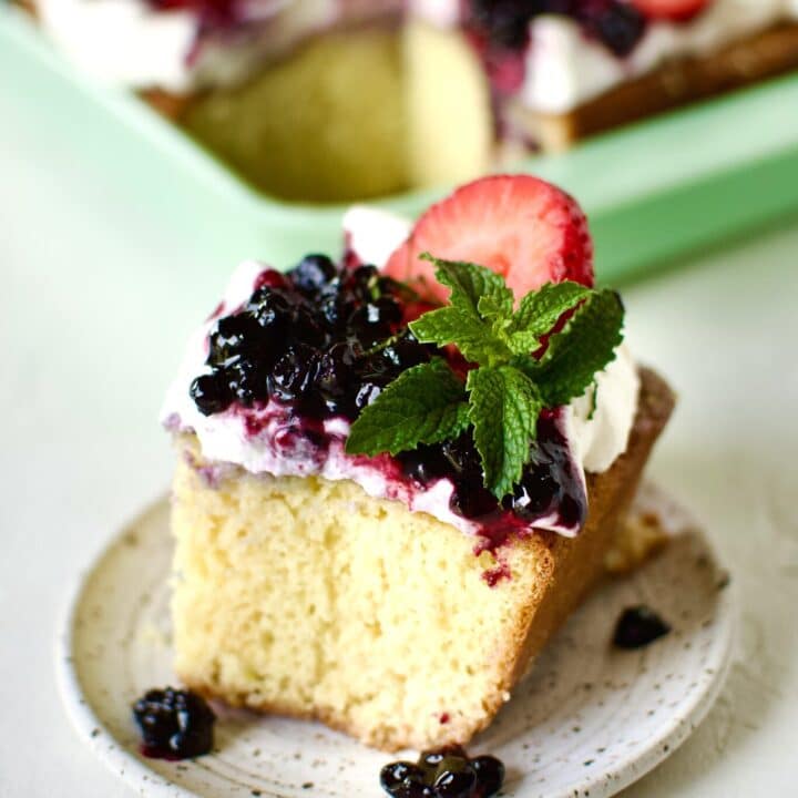Easy Tres Leches Cake, cut and a slice on a plate ready to eat.
