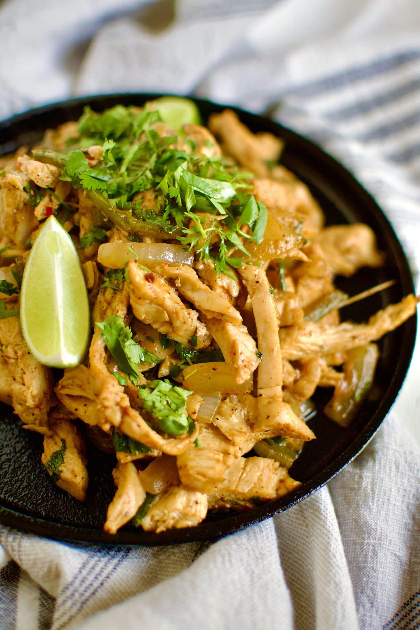 Easy Chicken Fajitas sizzling on a cast iron platter.