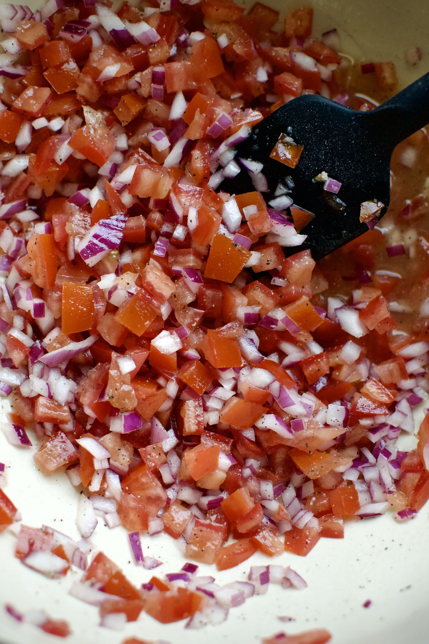 Dice Red Onions and Tomatoes in the bottom of a large bowl, seasoned with salt, pepper, and lime juice.