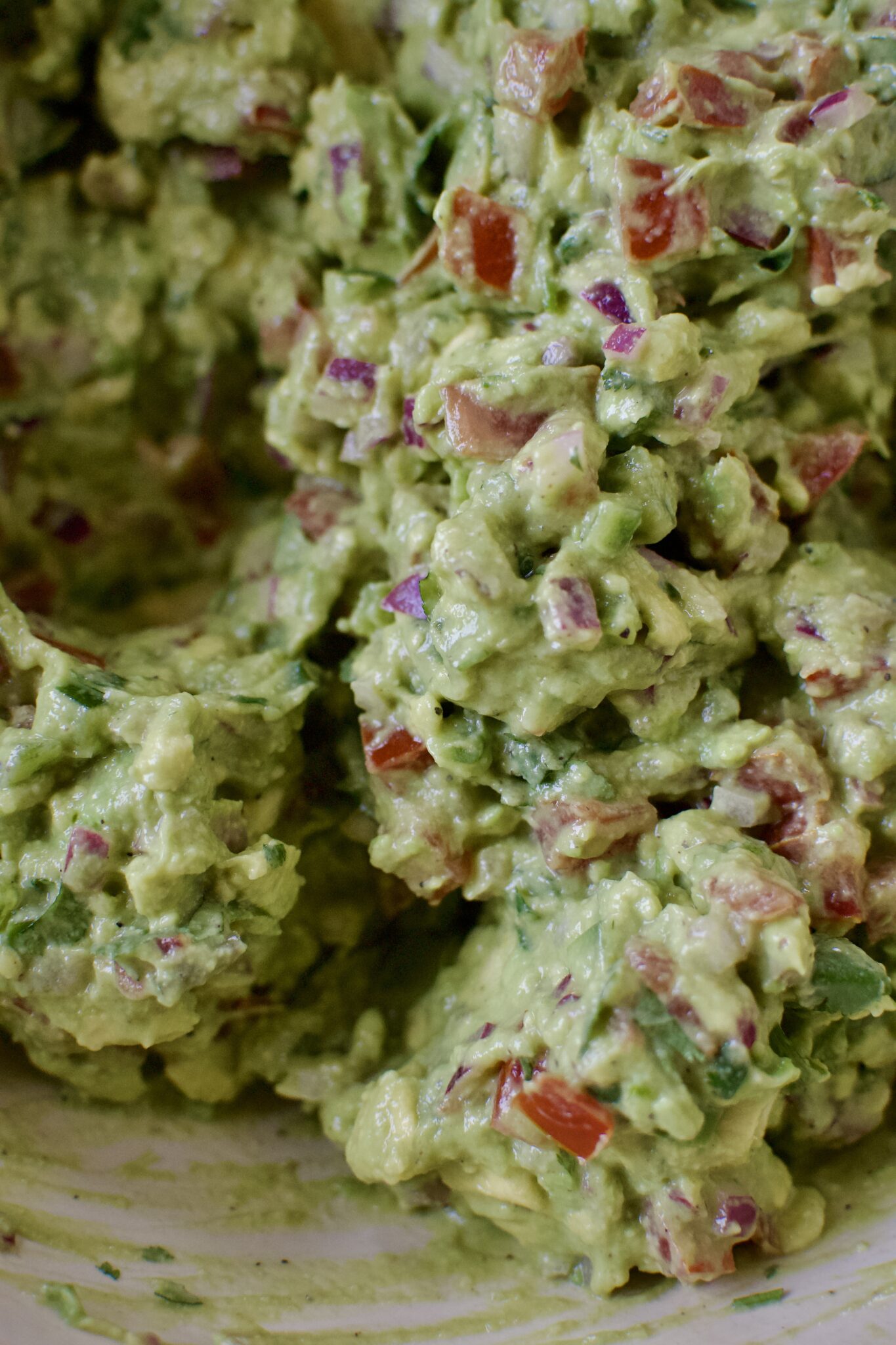 Freshly smashed and mixed guacamole in a large bowl.