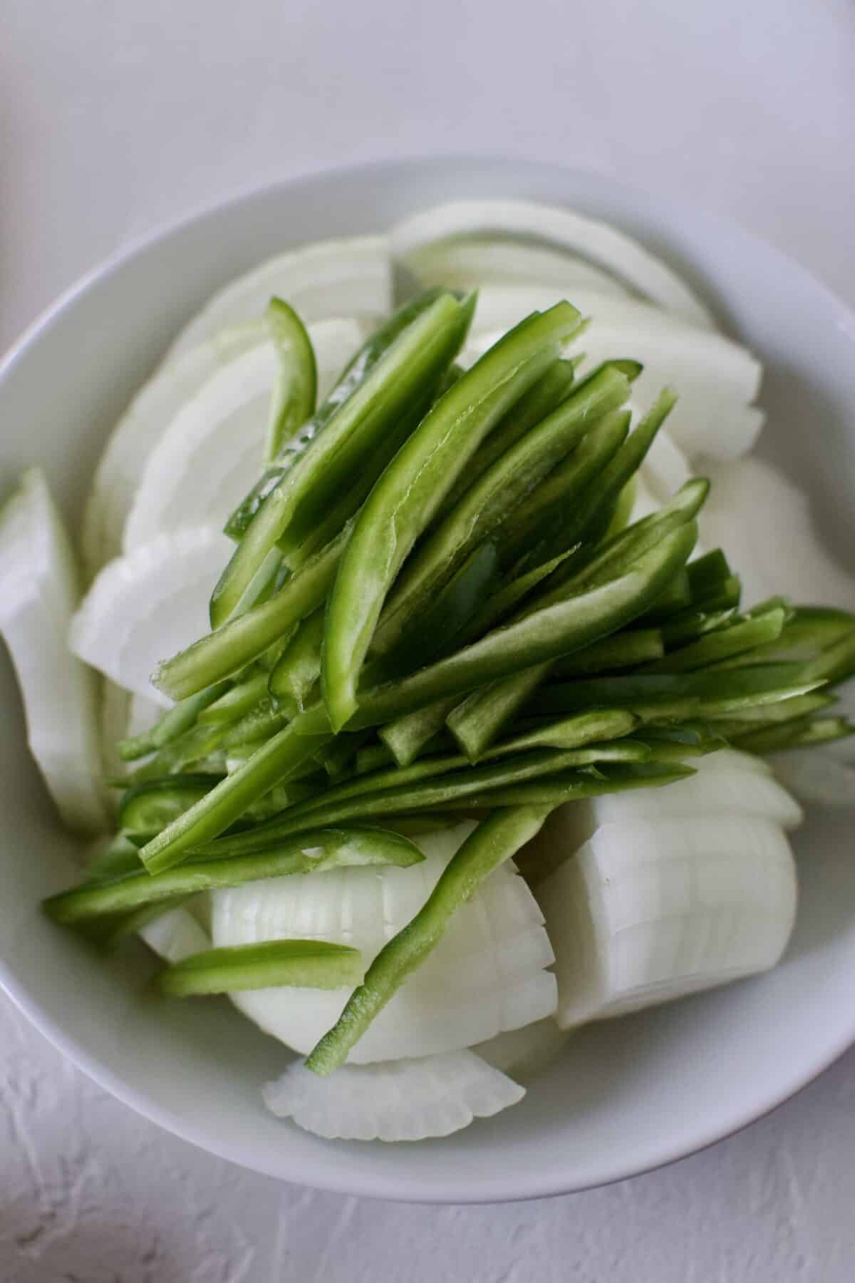 Sliced onions and jalapenos in a bowl.