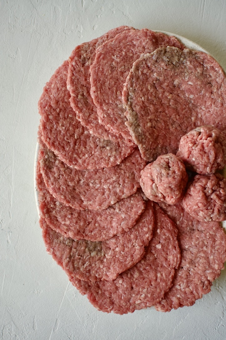 Making burger patties out of portioned ground beef.