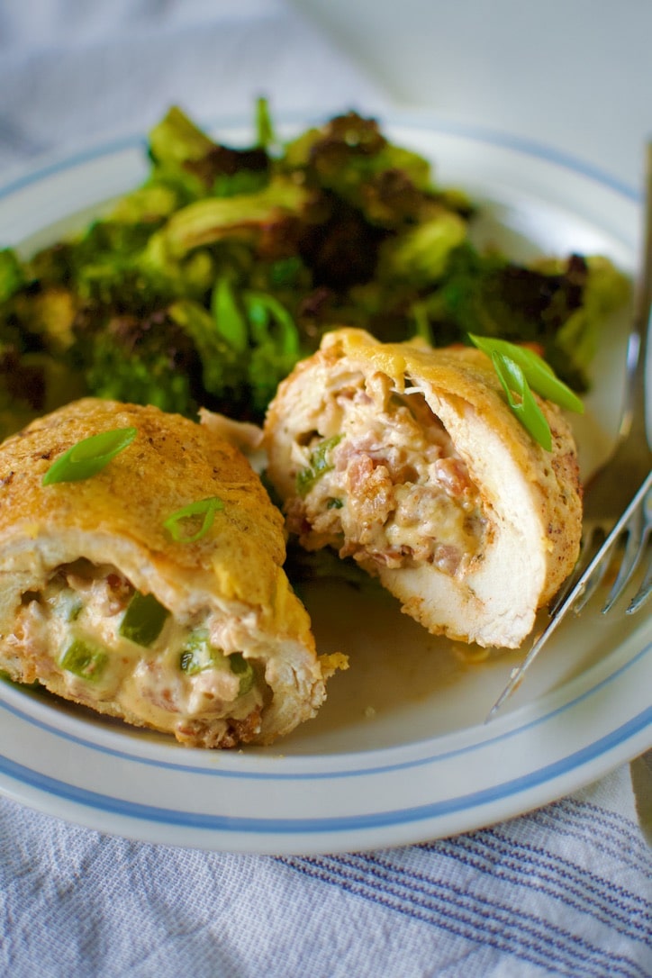 Stuffed Chicken Breast with Cheese cut open on a plate with roasted broccoli ready to eat.