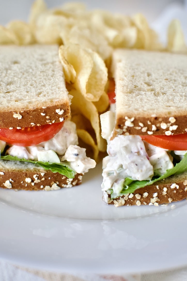Chicken Salad between two pieces of wheat bread to make a sandwich.