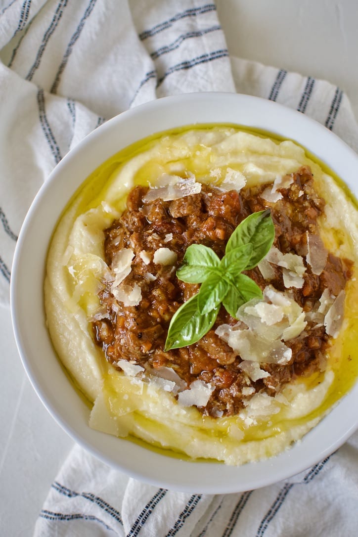 Short Rib Bolognese served over Creamy Polenta and topped with shaved parmesan and basil.