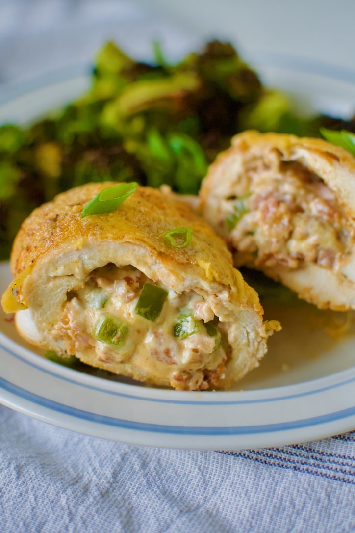 Stuffed Chicken Breast with Cheese cut open on a plate with roasted broccoli ready to eat.