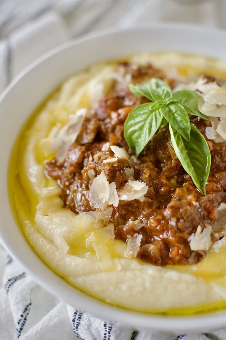 Short Rib Bolognese served over Creamy Polenta and topped with shaved parmesan and basil.