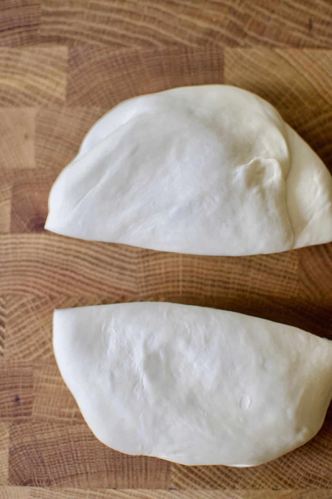 Pizza dough, split after rising and resting.