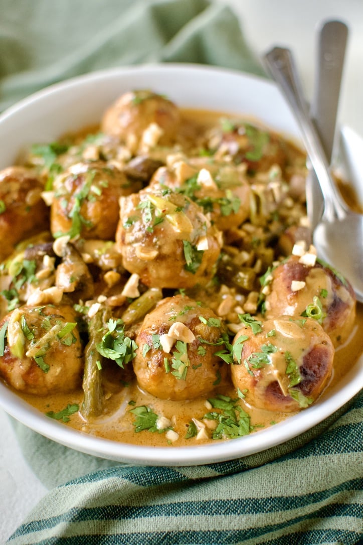 Ground Chicken Meatballs in Red Curry Sauce, served over rice noodles, in a bowl ready to eat.