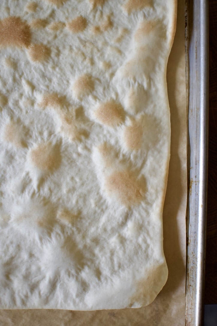 Thin-Crust Pizza Dough Recipe after baking, cracker thin crust ready to be topped.