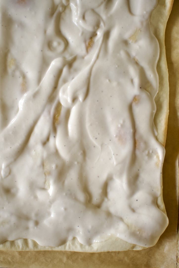 Cooked, Thin-Crust Pizza Dough Recipe, topped with alfredo sauce.