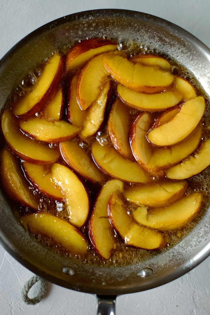 Maple syrup and whiskey added to the sauteed peaches, ready to top cooked pancakes.