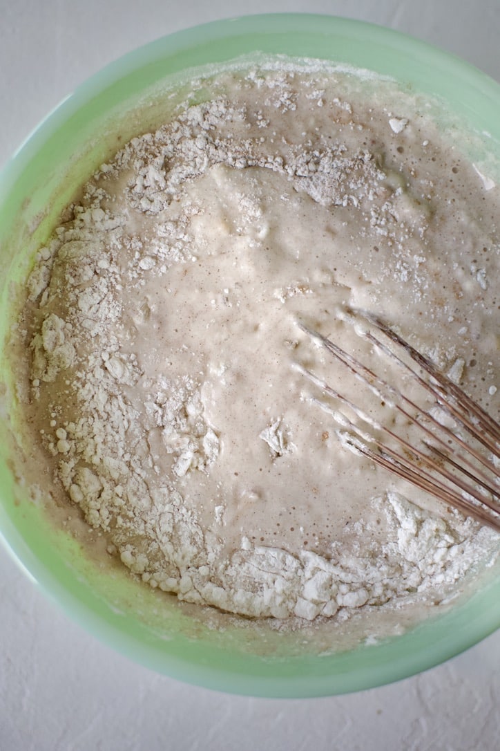 Whisking in the wet ingredients into the pancakes mix.