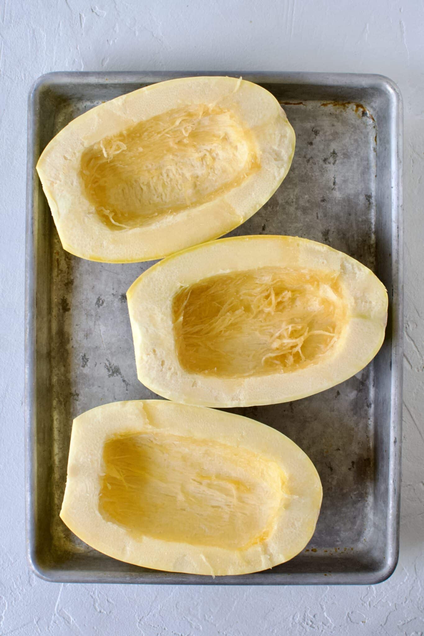 Spaghetti Squash, seeds removed, placed on a sheet pan.