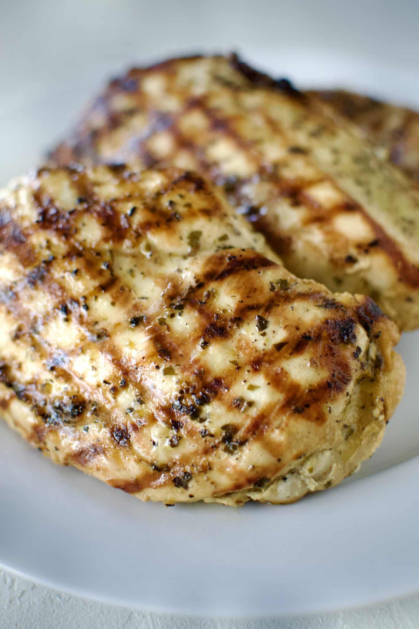 Italian Marinated chicken that has been grilled and is resting on a palate.