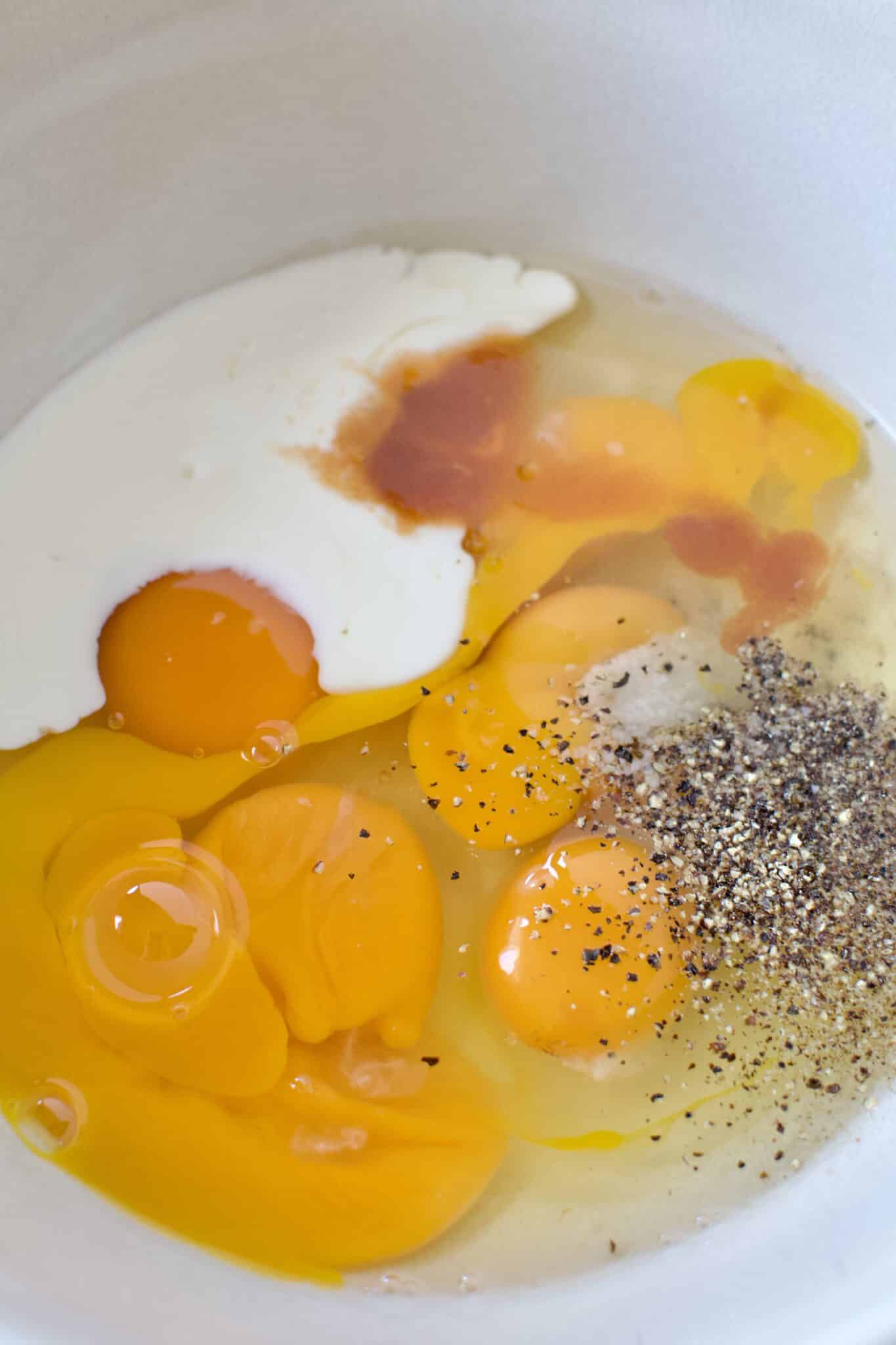 Eggs, Cream, hot sauce, salt, and pepper in a bowl ready to whipped up.