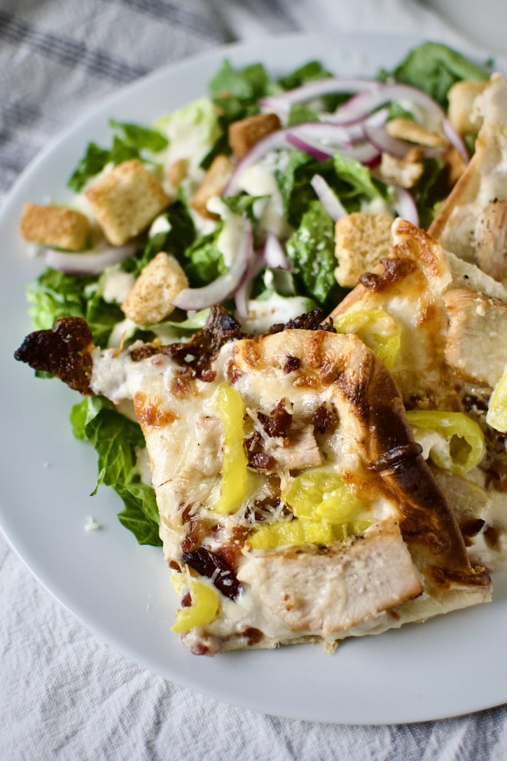 White Pizza Recipe pieces on a plate served with a salad.