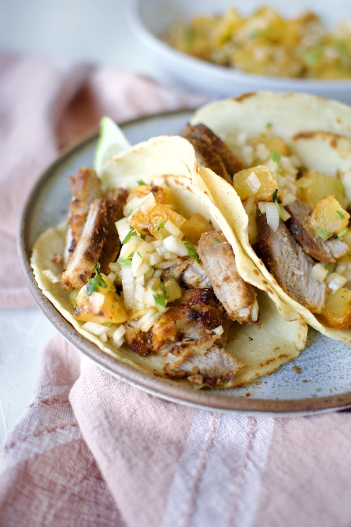 Al Pastor Taco Recipe in homemade corn tortillas topped with pineapple salsa.