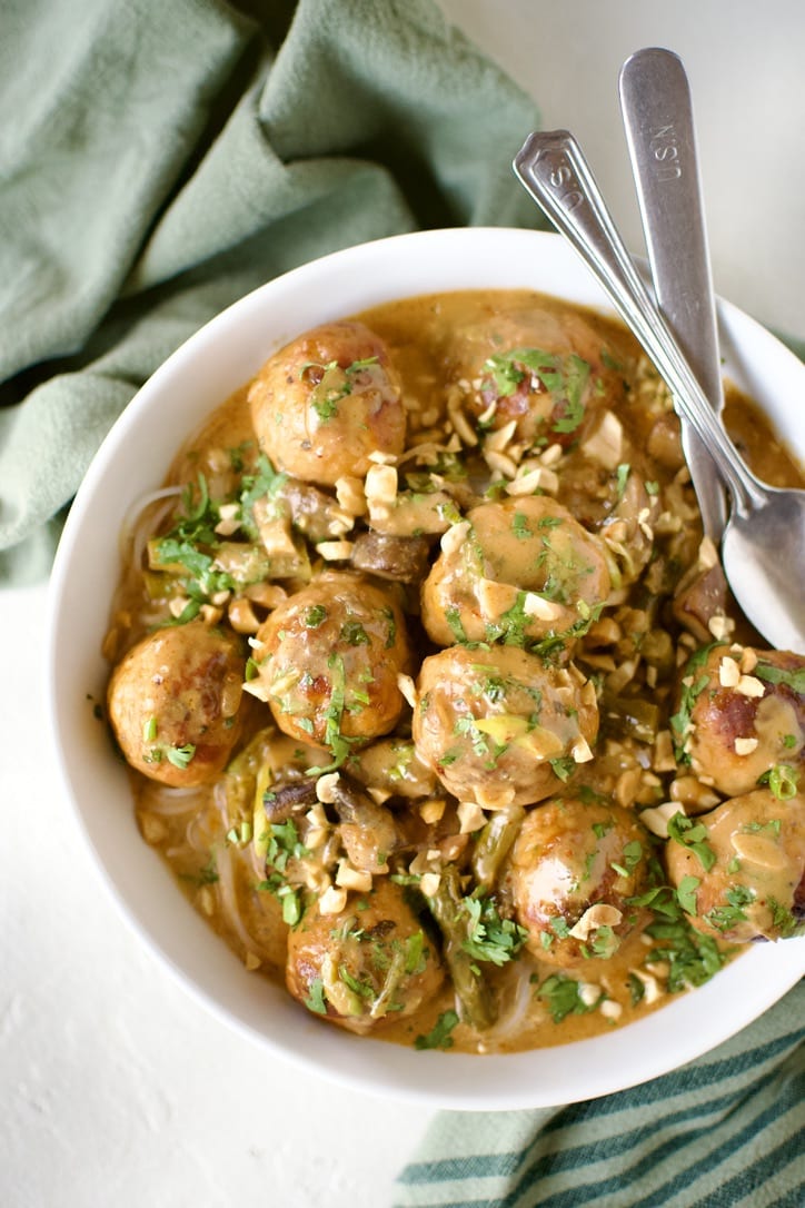 Ground Chicken Meatballs in Red Curry Sauce, served over rice noodles, in a bowl ready to eat.