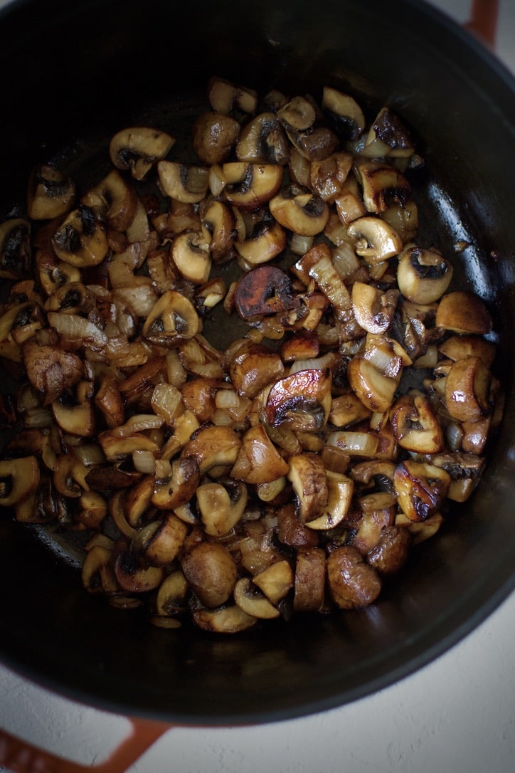 Onions and Mushrooms browned in the bottom of a large pot.