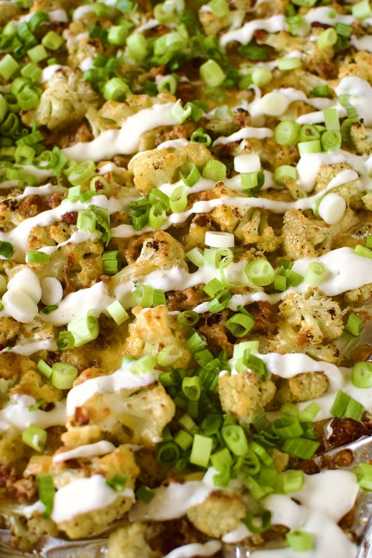 Loaded Baked Cauliflower on a sheet pan after cooking, ready to eat.