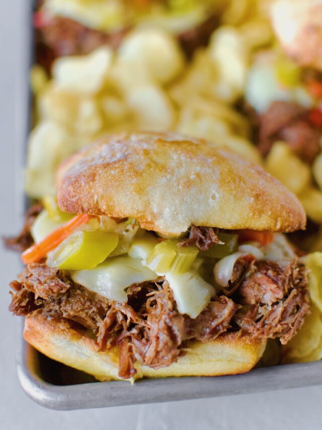 Close up shot of a single Chicago-Style Italian Beef Sandwiches served family style in a platter lined with kettle chips. Ready to be eaten!