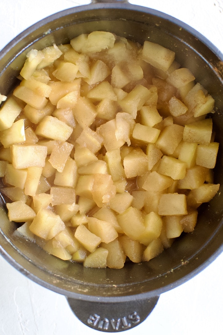 Cooked apples in the bottom of a pot, before smashing.