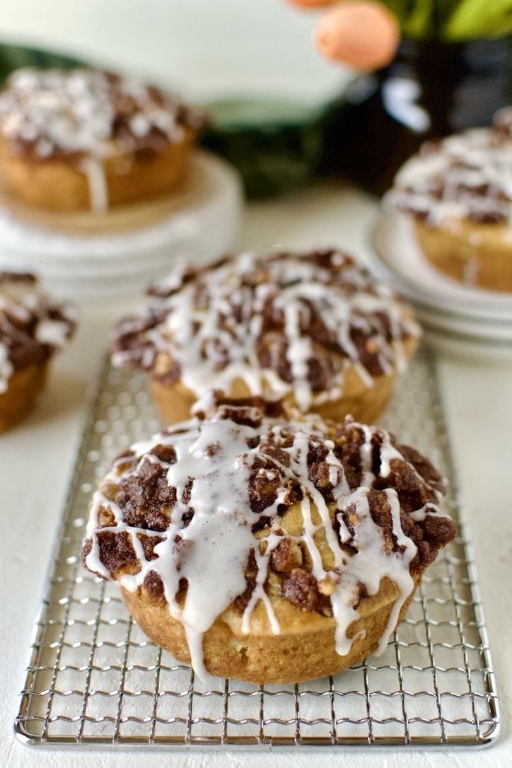 Glazed Apple Streusel Muffins on a table displayed and ready to eat.