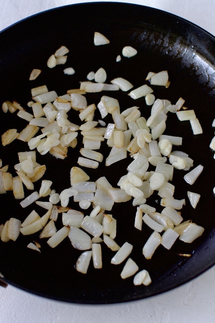 Sauteing onions in sesame oil in a large skillet.